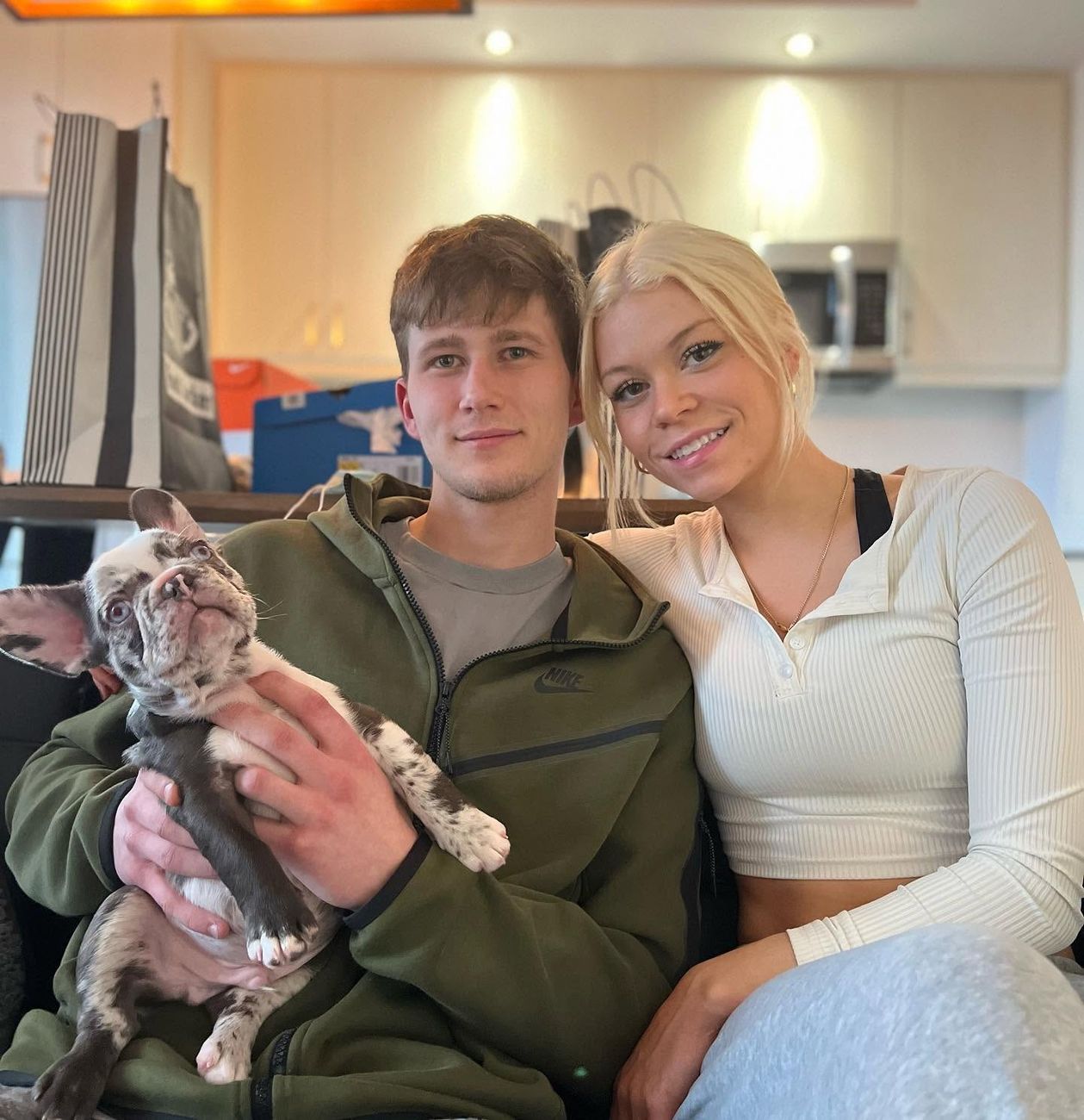 A couple at home with their new Frenchie puppy